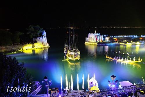 a river with boats in the water at night at Vip Lepanto Port Suites in Nafpaktos