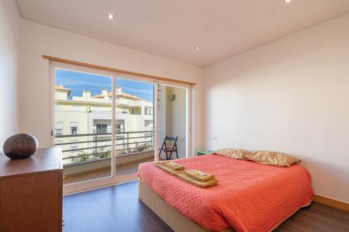ein Schlafzimmer mit einem Bett und einem großen Fenster in der Unterkunft Apartamento Correeira Deluxe by Umbral in Albufeira