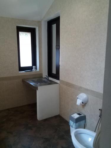 un bagno con lavandino, WC e finestra di Villa Chaya a Khao Lak