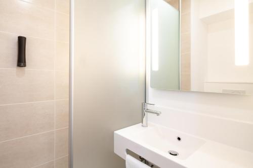 y baño con lavabo blanco y espejo. en B&B HOTEL Bordeaux Saint André de Cubzac, en Saint-André-de-Cubzac