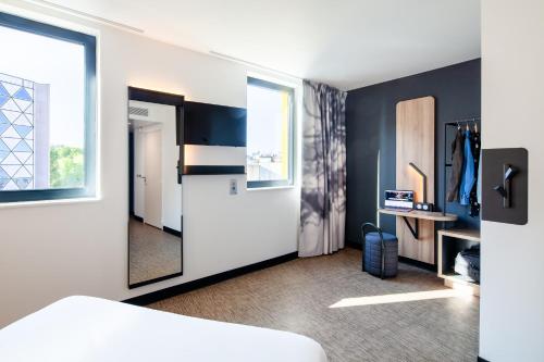 a room with a bed and a desk and a window at B&B HOTEL Bordeaux Saint André de Cubzac in Saint-André-de-Cubzac