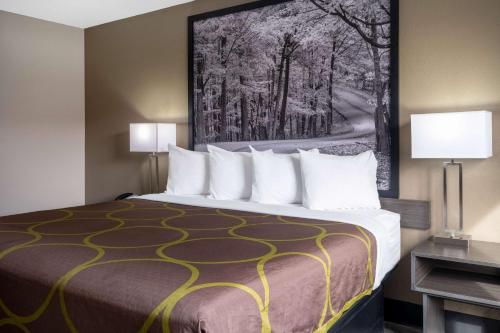 a bedroom with a large bed with two lamps at Super 8 by Wyndham Merrillville in Merrillville