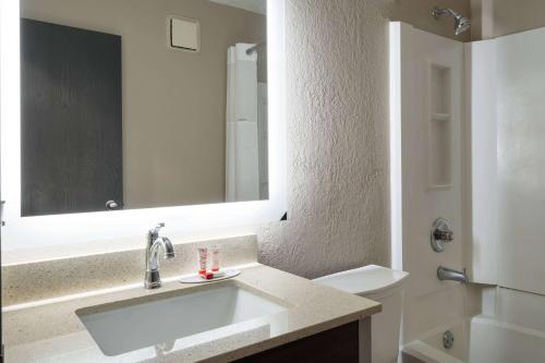 a bathroom with a sink and a mirror at Super 8 by Wyndham Merrillville in Merrillville