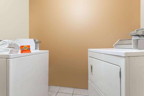 a laundry room with a washer and dryer at Days Inn by Wyndham Orange in Orange