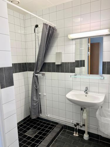 y baño con lavabo y ducha. en Vandrarhem Nattmössan, en Kungsbacka