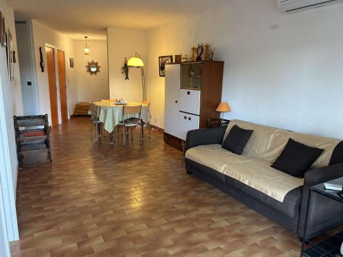 un salon avec un canapé et une table dans l'établissement Appartement T2 6 couchages avec jardin privé et terrasse au Grau-du-Roi, à deux pas de la mer - FR-1-250-223, au Grau-du-Roi
