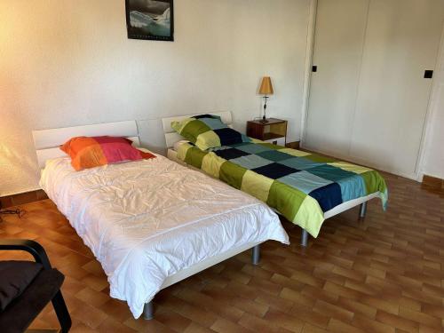 deux lits côte à côte dans une pièce dans l'établissement Appartement T2 6 couchages avec jardin privé et terrasse au Grau-du-Roi, à deux pas de la mer - FR-1-250-223, au Grau-du-Roi