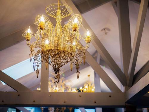 a large chandelier hanging from a ceiling at Hôtel Mercure Paris Suresnes Longchamp in Suresnes