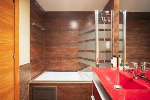 a bathroom with a red sink and a shower at Lucas House Apartments by Sitges Group in Sitges