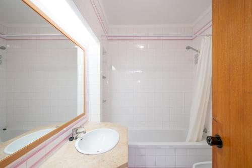 uma casa de banho com um lavatório e uma banheira em Sunholidays Apartment by Umbral em Albufeira