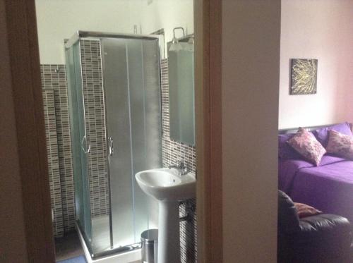 a bathroom with a sink and a glass shower at B&B Luce Viola in Dorgali