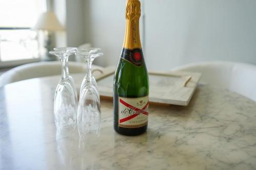 - une bouteille de champagne et 2 verres à vin sur un comptoir dans l'établissement Appartement familial pour 4 pers et 2 bébés face à la Baie, à Saint-Valery-sur-Somme
