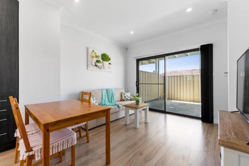 a kitchen and dining room with a table and a couch at Swainson on Bernards in Campbelltown