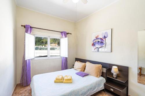 a bedroom with a bed with purple curtains and a window at Travessa Albufeira Apartments by Umbral in Albufeira