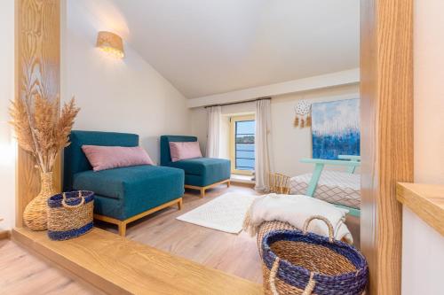 sala de estar con sofá azul y silla en Exclusive Seafront Bacchus Apartment, en Poreč