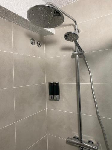 a shower with a shower head in a bathroom at El Patio Hostal in Alicante