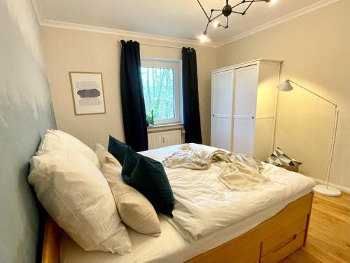een slaapkamer met een bed met witte lakens en kussens bij FeWo Phönixhütte am Baldeneysee in Kupferdreh in Essen