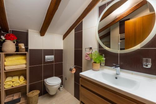 y baño con lavabo, aseo y espejo. en Exclusive Seafront Bacchus Apartment, en Poreč