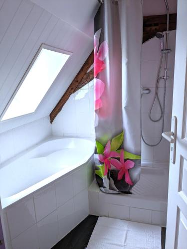 a bathroom with a bath tub and a window at La Borie du Chevrier in Sainte-Croix-de-Beaumont