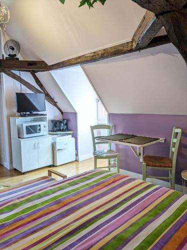 a room with a bed and a table and chairs at La Borie du Chevrier in Sainte-Croix-de-Beaumont