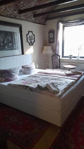 a large bed in a bedroom with a window at Pension Alte Schmiede in Greifswald
