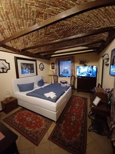 a bedroom with a large bed and two televisions at Pension Alte Schmiede in Greifswald