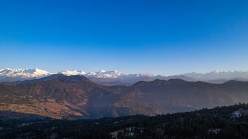 a view of a mountain range with snow capped mountains at THE HIMALAYAN WOODS, CHAUKORI in Chaukori