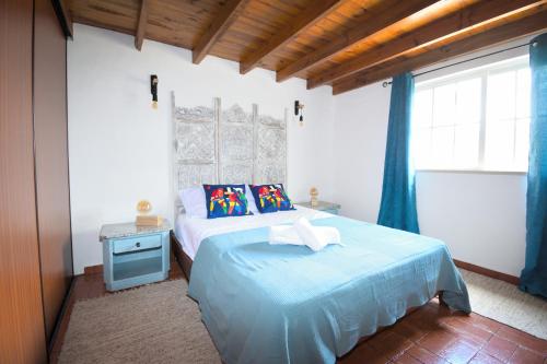 a bedroom with a blue bed with a blue nightstand at Casa Coriska in Algoz