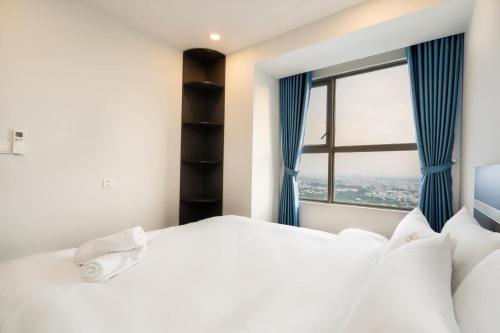 ein Schlafzimmer mit einem großen weißen Bett und einem Fenster in der Unterkunft River Panorama 2Bedroom*Kingbed*Infinity Pool in Ho-Chi-Minh-Stadt