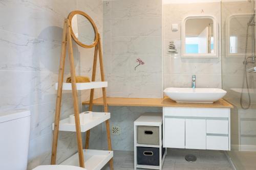 bagno con lavandino bianco e specchio di Deluxe Oldtown by Umbral ad Albufeira