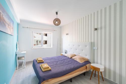 una camera da letto con un letto con lenzuola viola e un tavolo di Deluxe Oldtown by Umbral ad Albufeira