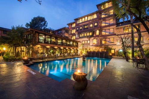 um hotel com piscina em frente a um edifício em The Dwarika's Hotel em Kathmandu