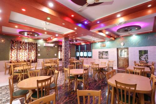 un restaurante con mesas y sillas en una habitación en Flavours Restaurant And Resort "A unit of Sidhbali Restaurant", Dugadda, en Lansdowne