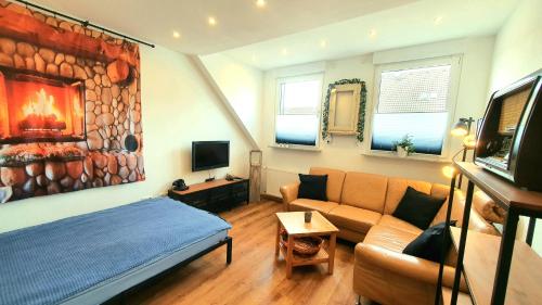 een woonkamer met een bank en een bed in een kamer bij FRANKES CITY SLEEP Maisonette Apartment, 6 Einzelbetten in Velbert