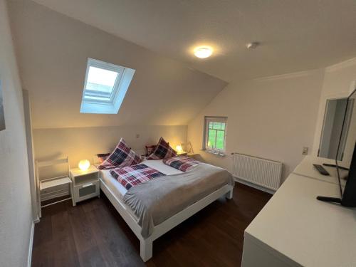 een slaapkamer met een bed met kussens en een raam bij Weideblick in Upgant-Schott