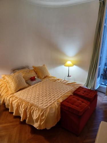- une chambre avec un grand lit et une couette jaune dans l'établissement Toureifelchampselysee, à Paris