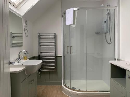 a bathroom with a glass shower and a sink at Waverley B & B in Minehead