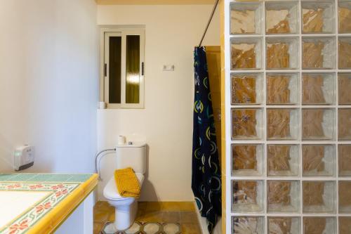 a bathroom with a toilet and a glass block shower at Villa Serenity B&B in Sannat