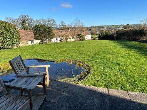 a wooden chair sitting on a patio next to a pond at Llais Y Mor in Carmarthen