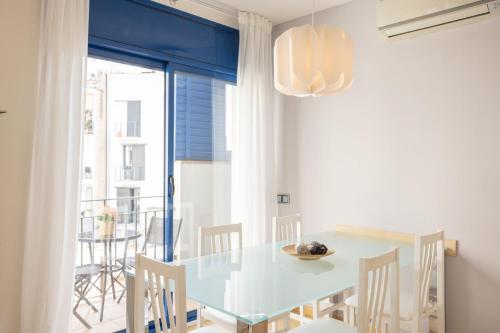 a dining room with a blue table and chairs at Lucas House Apartments by Sitges Group in Sitges