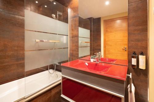 a bathroom with a red sink and a bath tub at Lucas House Apartments by Sitges Group in Sitges