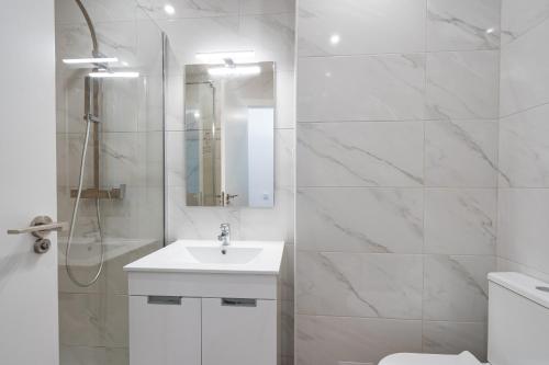 a white bathroom with a sink and a shower at Apartamento Deluxe Oldtown 30 by Umbral in Albufeira
