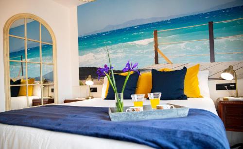 Luxury Singular Villa Canelas في سانكسينكسو: غرفة نوم بسرير مع كأسين من عصير البرتقال