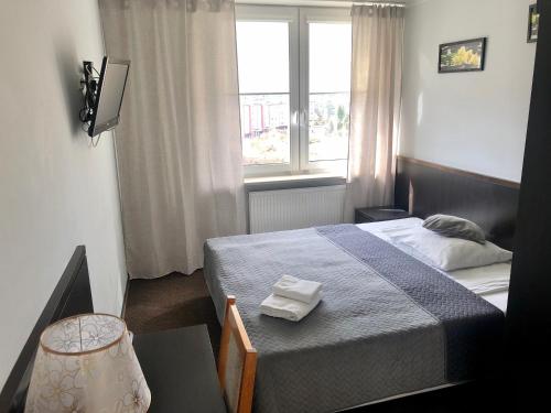 a small bedroom with a bed and a window at Sosnowe Zacisze in Białystok