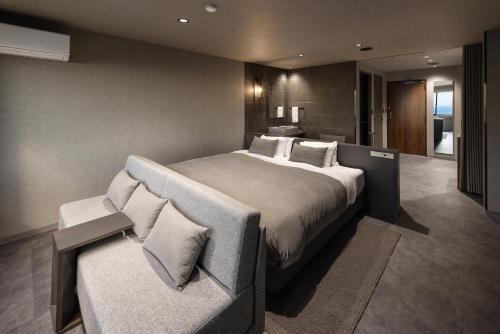 a bedroom with a large bed and a couch at TheMana Village in Tosashimizu