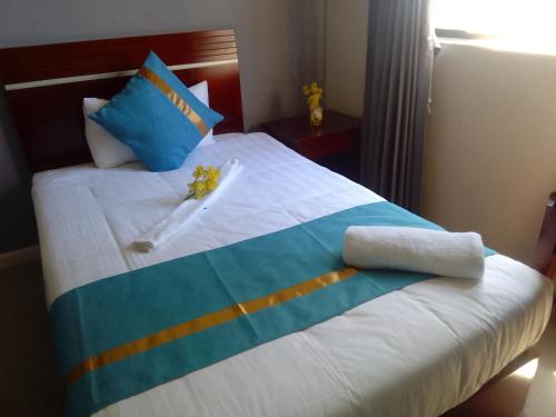 a hotel room with a white bed with blue and orange stripes at Atlantic Pearl Guest House Midrand in Midrand