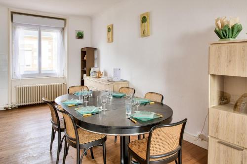 une salle à manger avec une table et des chaises noires dans l'établissement À 600m de la plage, maison pour 6 avec terrasse, au Guilvinec