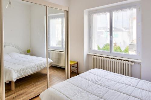 a bedroom with two beds and a window at À 600m de la plage, maison pour 6 avec terrasse in Le Guilvinec