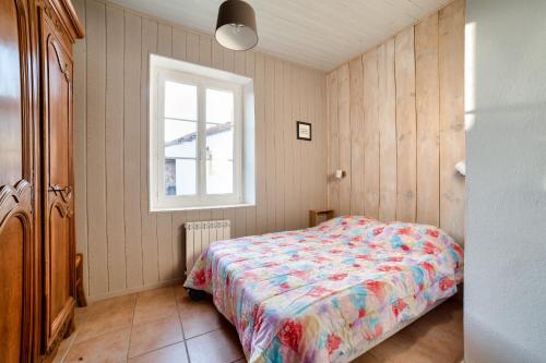 um pequeno quarto com uma cama e uma janela em Jolie Maison à Noirmoutier-en-ile pour 4 personnes em Noirmoutier-en-l'lle