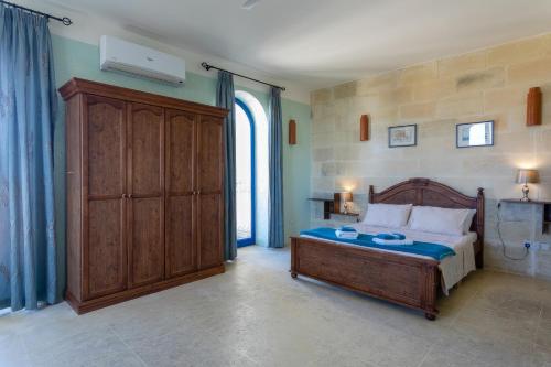 a bedroom with a bed and a large window at Villa Serenity B&B in Sannat